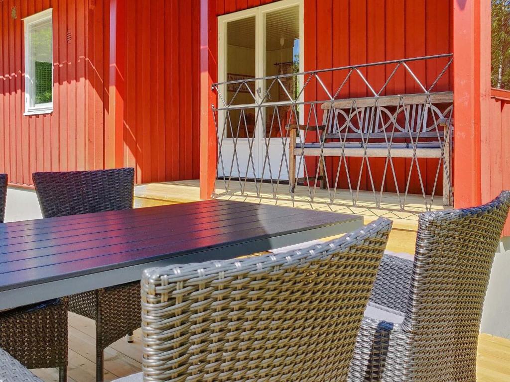 a wooden table and chairs on a patio at Holiday home Östhammar III in Östhammar