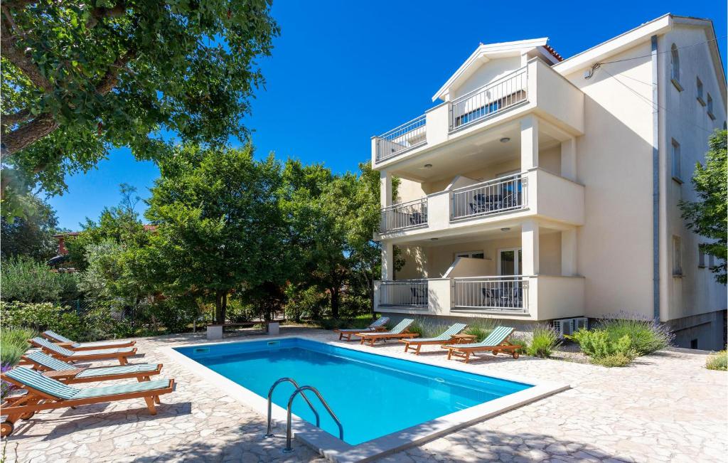 une villa avec une piscine en face d'un bâtiment dans l'établissement Awesome Apartment In Pinezici With 2 Bedrooms, Wifi And Outdoor Swimming Pool, à Pinezići