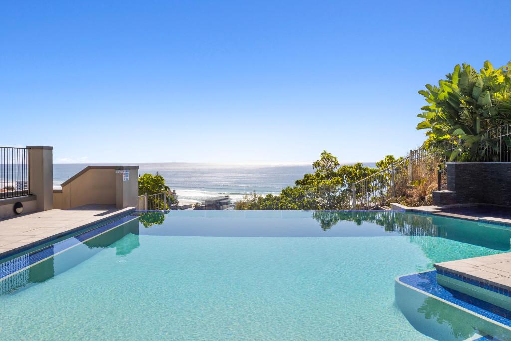 a swimming pool with a view of the ocean at Luxury Stunning Nobby's Beach Home 2bd + Den ! in Gold Coast