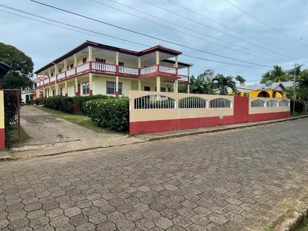 una casa con una valla al lado de una calle en Sunrise Hotel en Corn Island