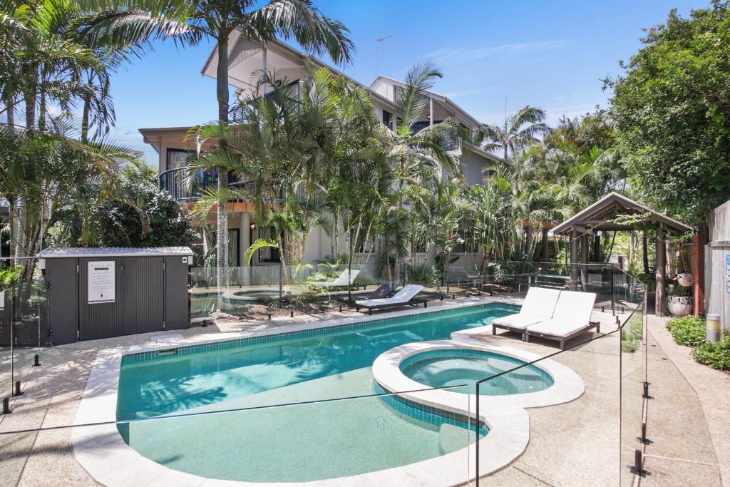 a swimming pool in front of a house at Gosamara Apartments in Byron Bay