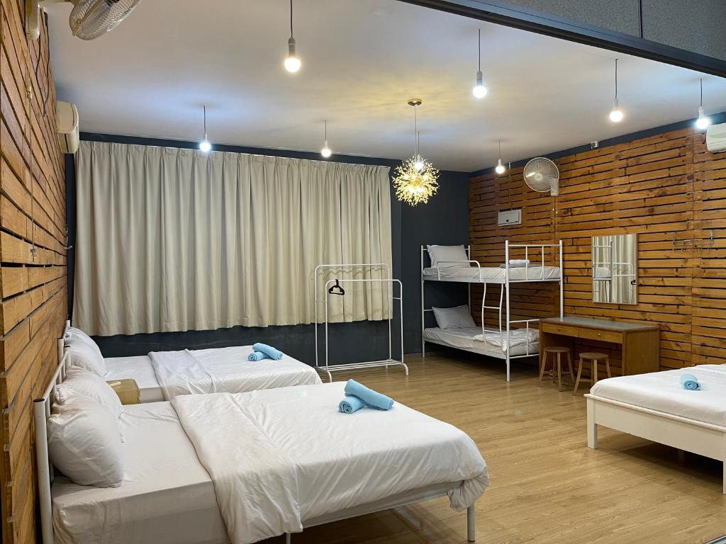 a bedroom with two beds and a room with a table at Stylishly Spacious in Tanjung Bungah