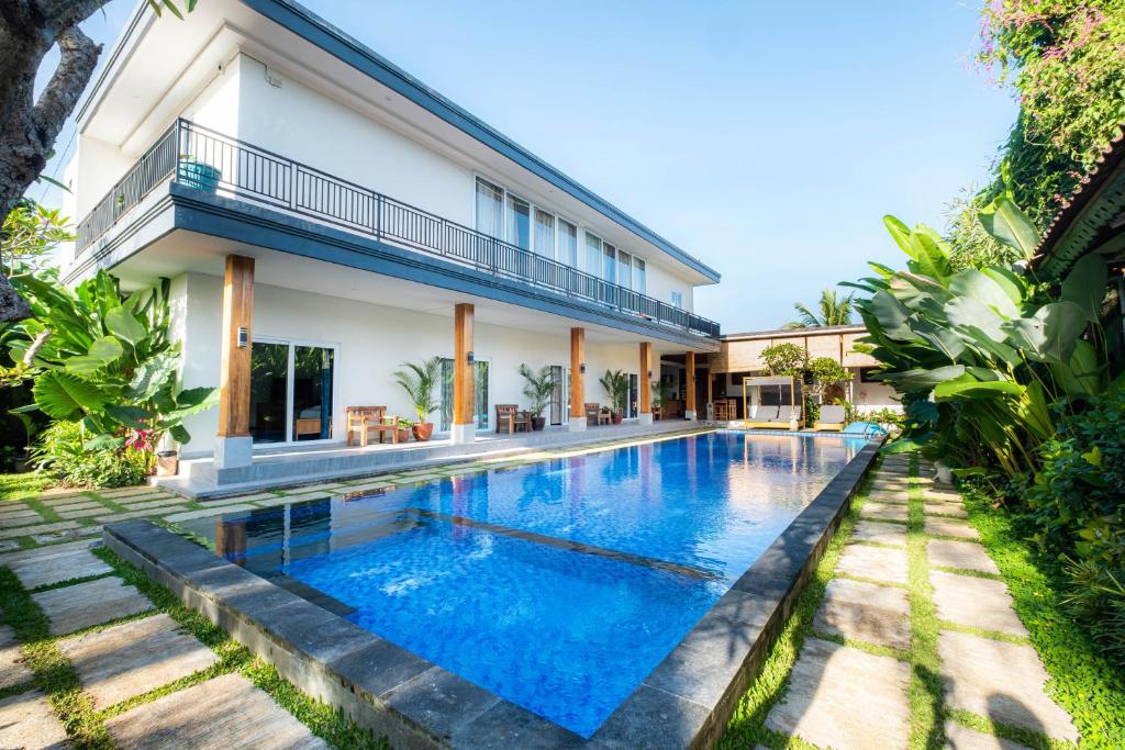 uma imagem de uma piscina em frente a uma casa em Kubu Kirana by Supala em Ubud