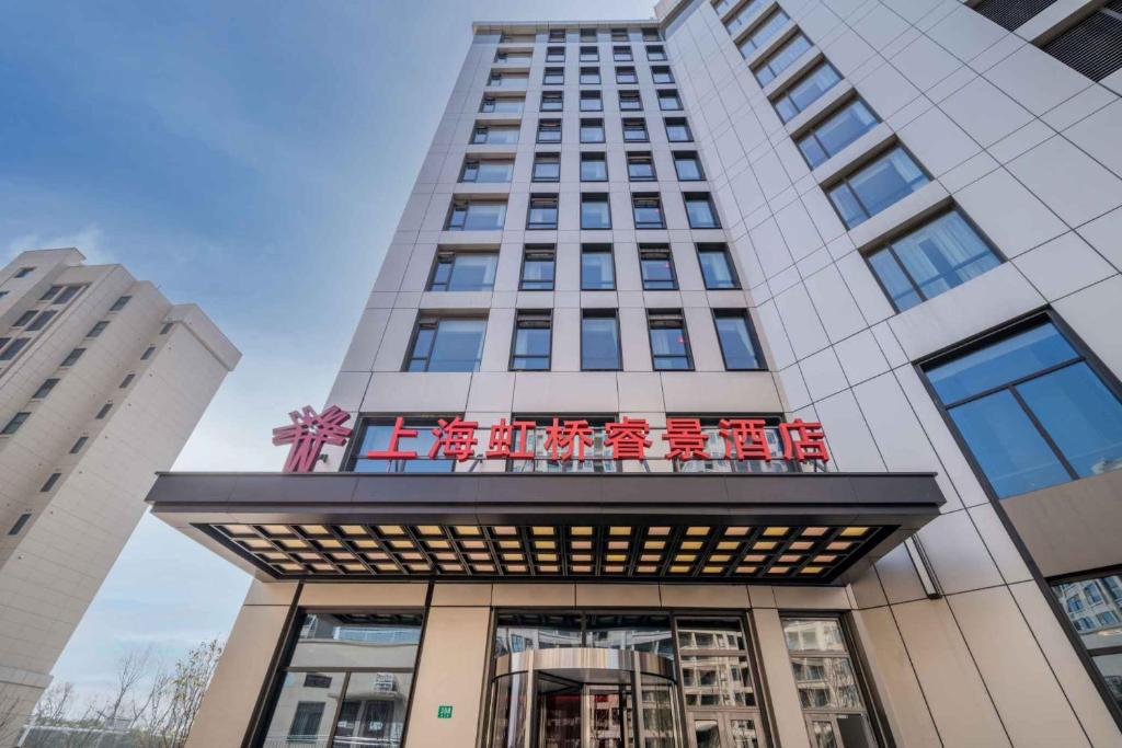 Kew Green Hotel Hongqiao Shanghai في شانغهاي: مبنى طويل عليه لافته على الواجهه