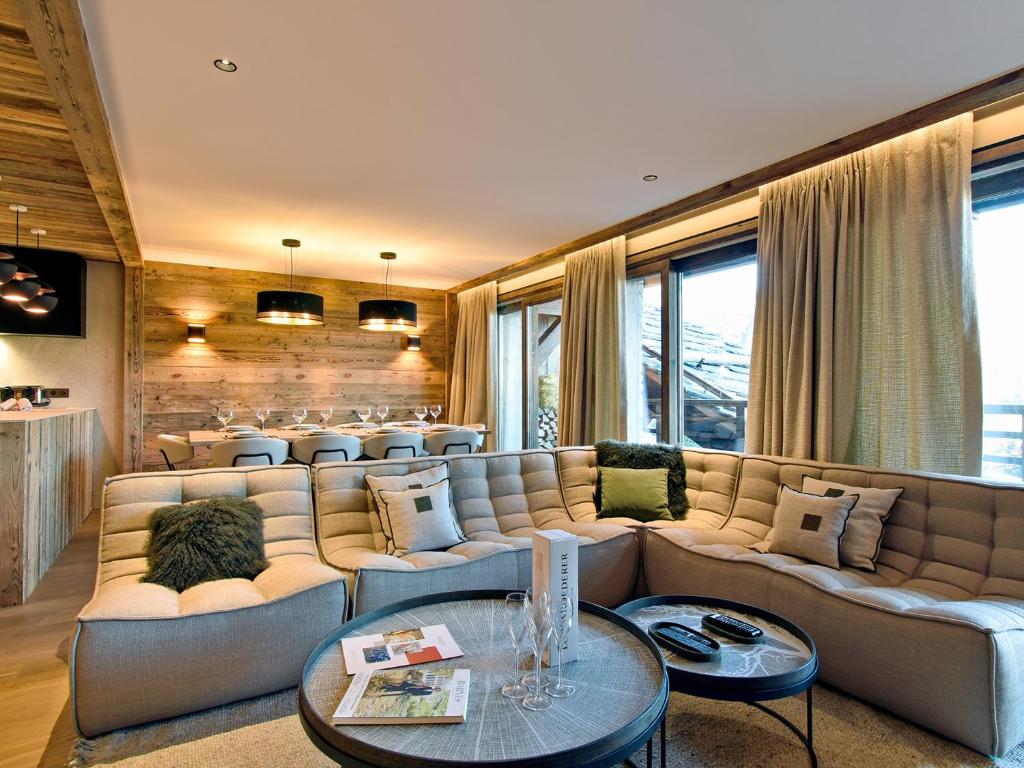 a living room with a large couch and tables at Appartement chic Méribel - skis aux pieds, cheminée & parking - FR-1-613-40 in Méribel