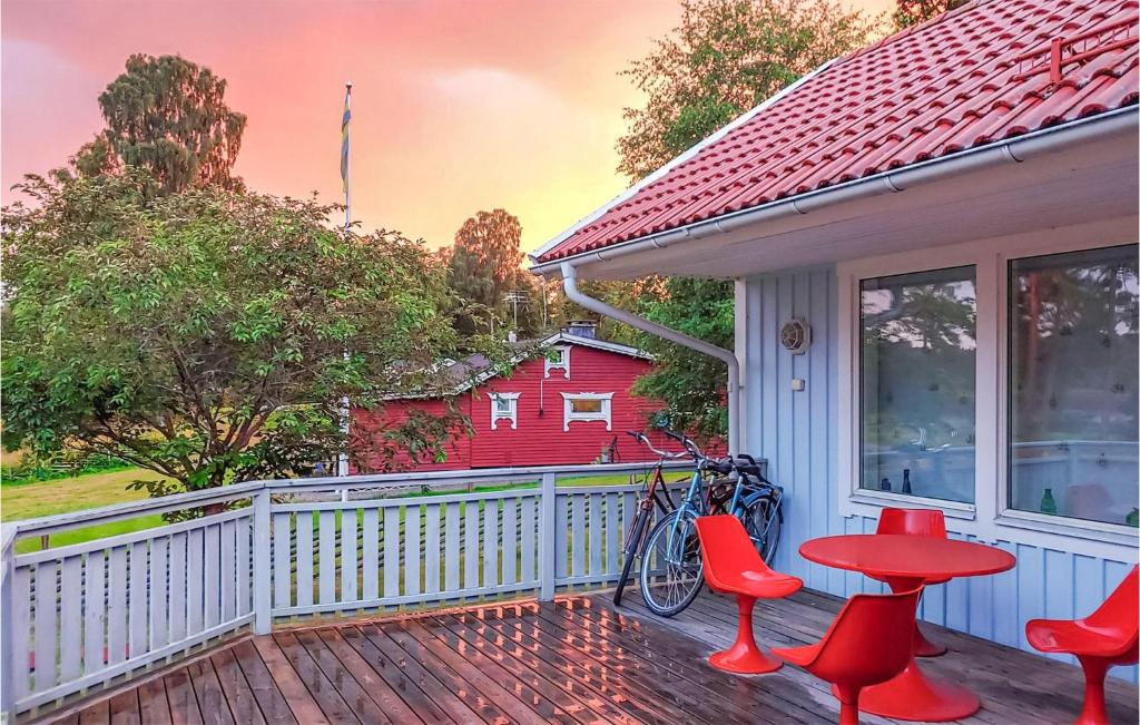 a porch with red chairs and a red house at Amazing Home In Hkerum With Sauna, 3 Bedrooms And Wifi in Hökerum