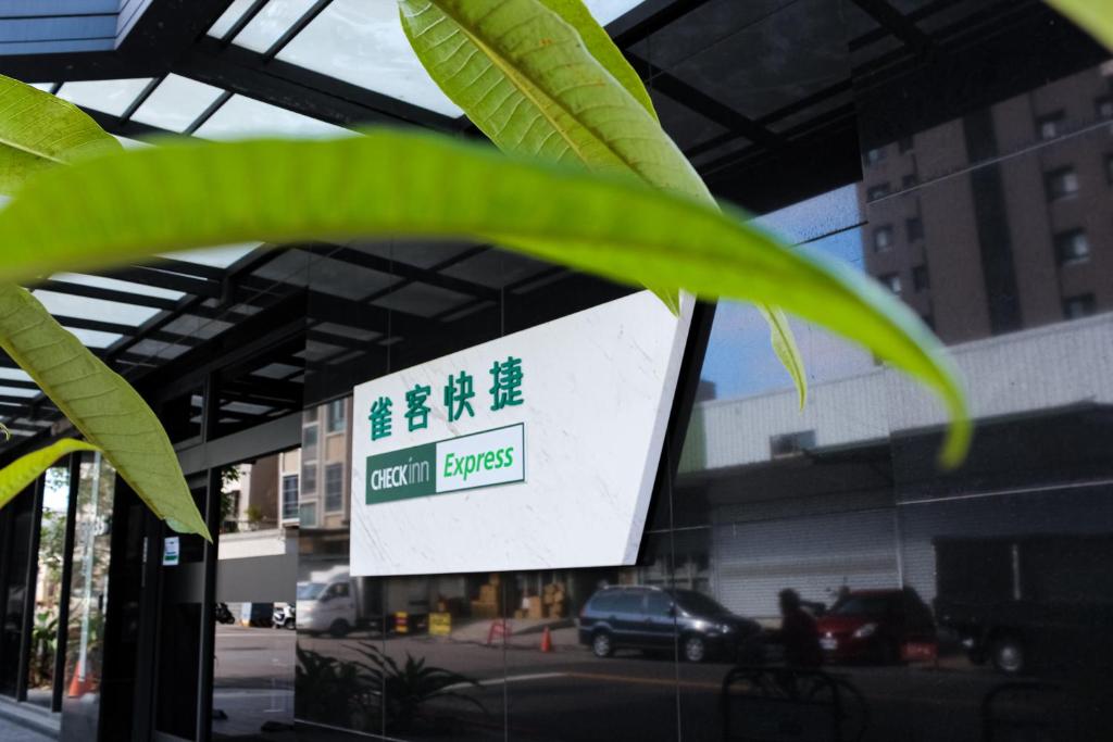 un cartello di fronte a un edificio con garage per auto di CHECK inn Express Taichung FuXing Hall 2 a Taichung
