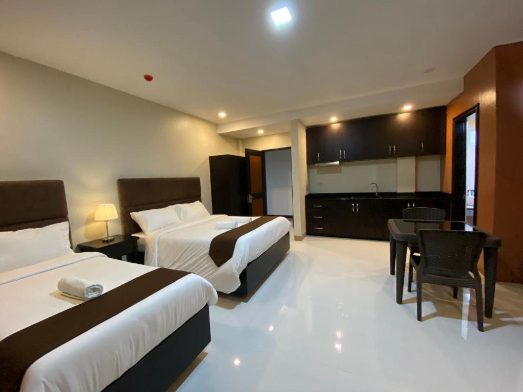 a hotel room with two beds and a kitchen at Eight Breeze in Baclayon