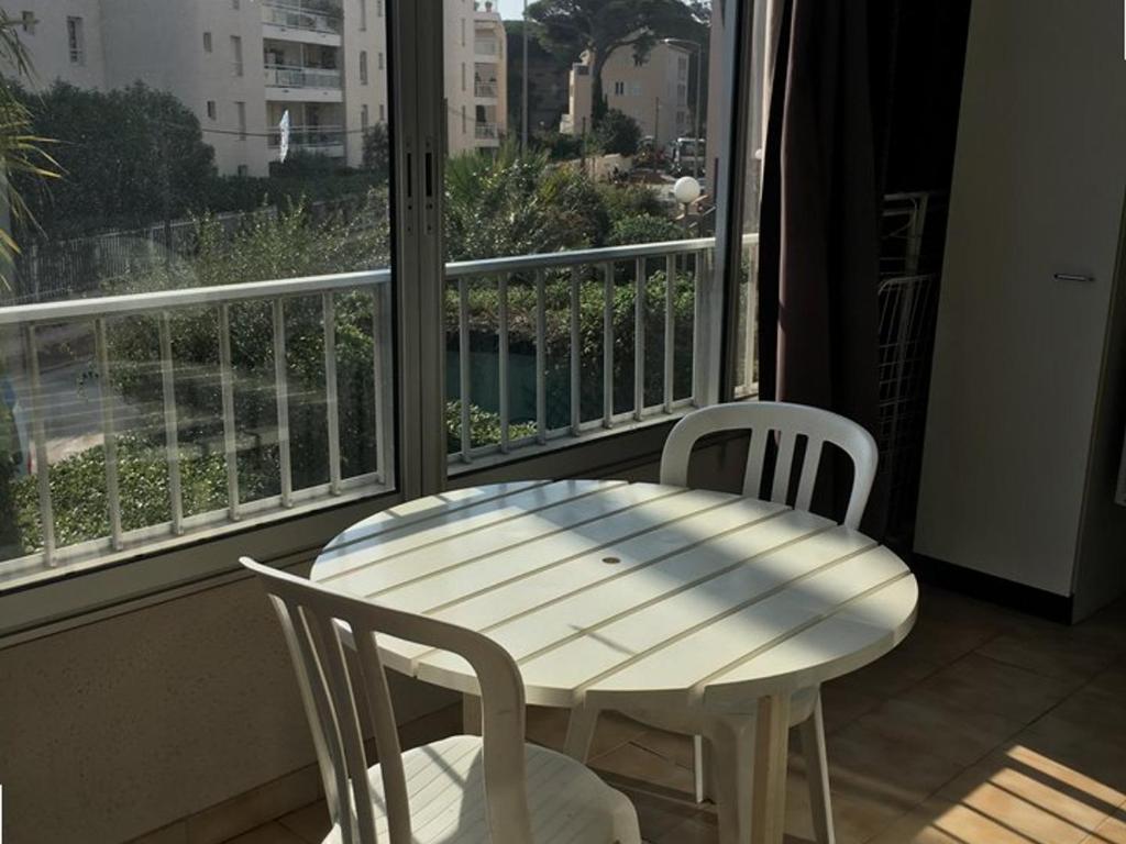 una mesa blanca y sillas en un balcón con ventana en Studio Hyères, 1 pièce, 4 personnes - FR-1-335-186, en Hyères