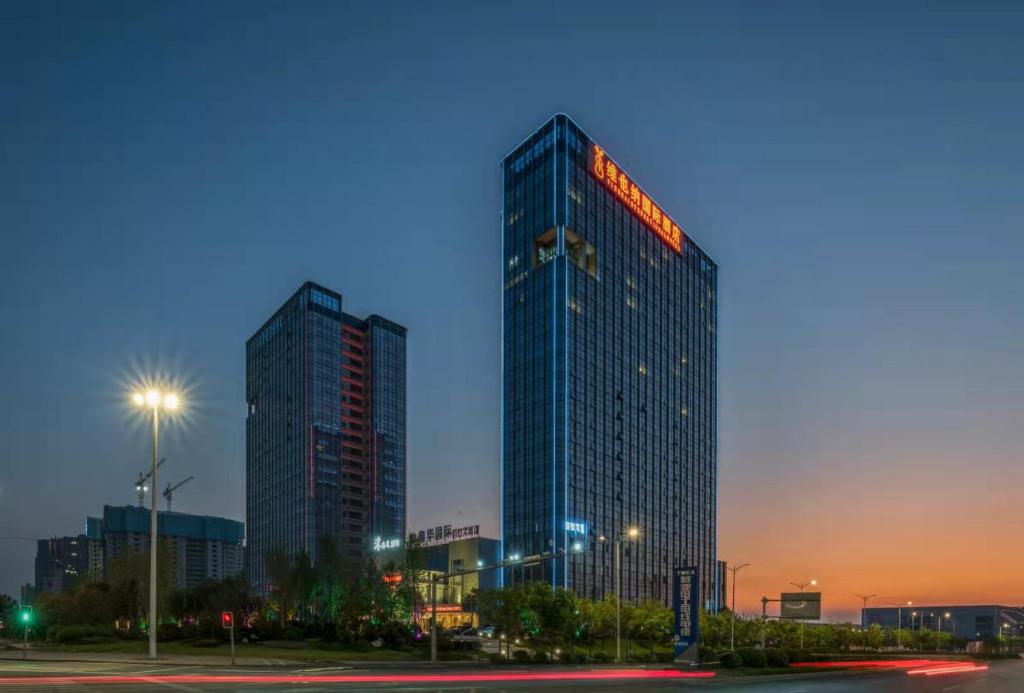 a tall building with a sign on it in a city at Vienna International Hotel Hengyang Huayao city in Hengyang