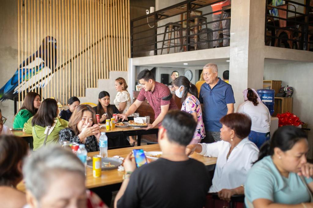 a group of people sitting at tables in a restaurant at HappyNest Hostel Cebu in Cebu City