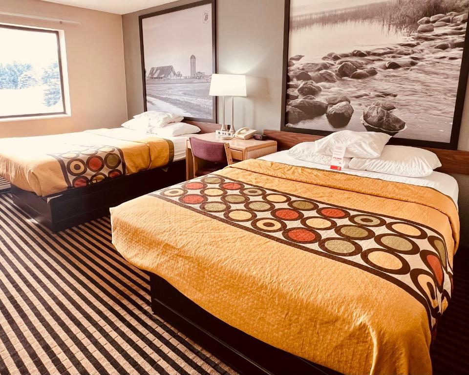 um quarto de hotel com duas camas e um quadro na parede em Super 8 by Wyndham Humboldt em Humboldt