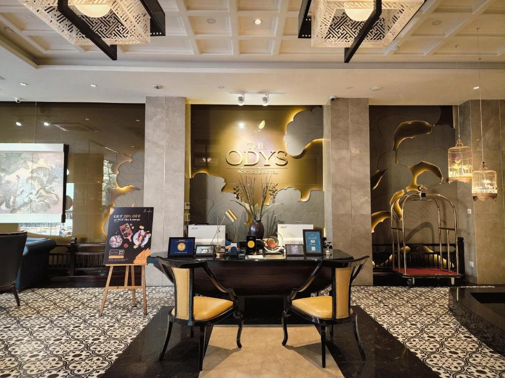 a lobby of a hotel with a desk and chairs at The Odys Boutique Hotel in Ho Chi Minh City