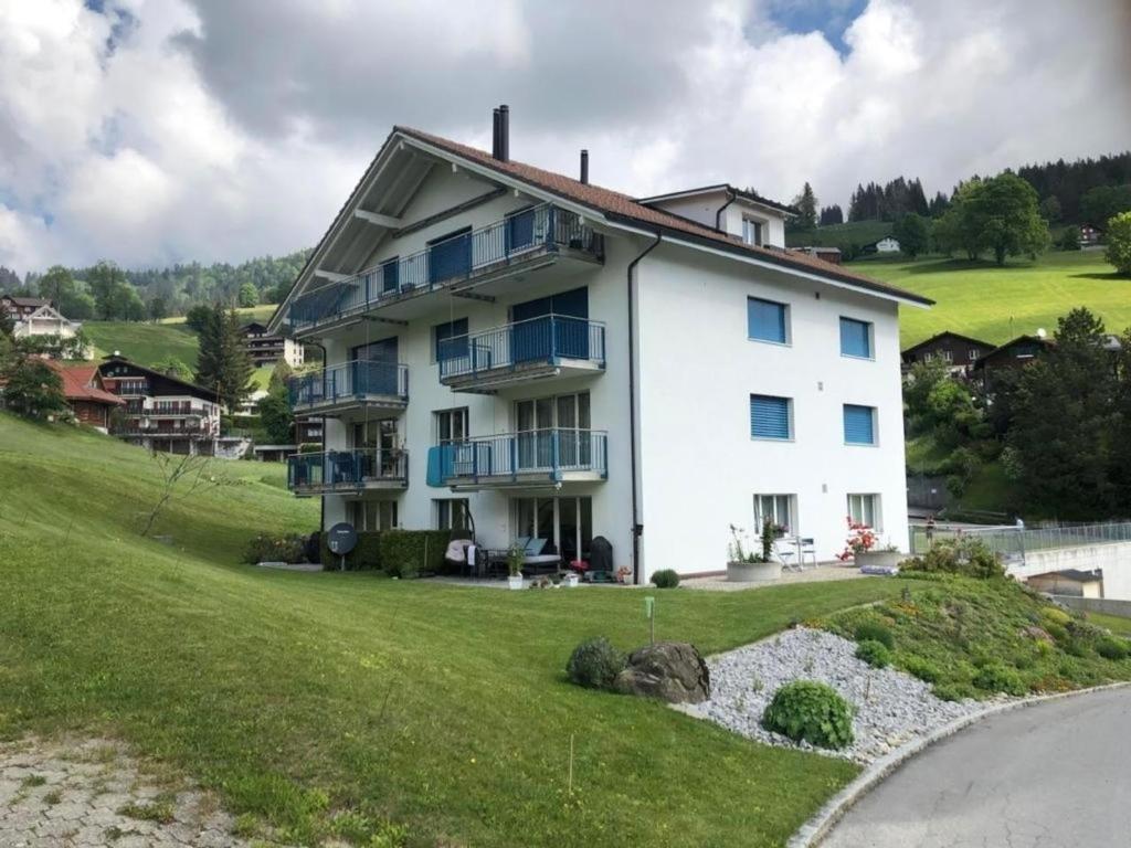 a large white house on top of a green hill at Erholung in Wildhaus mit Bergsicht in Wildhaus