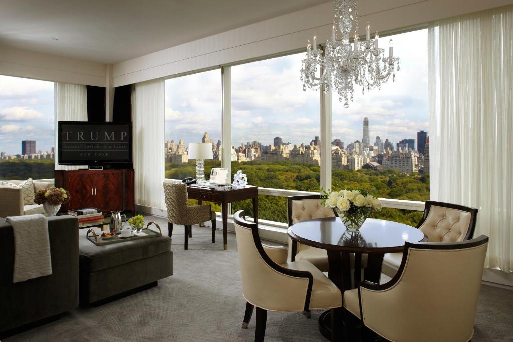 a living room with a chandelier and a table and chairs at Trump International New York in New York
