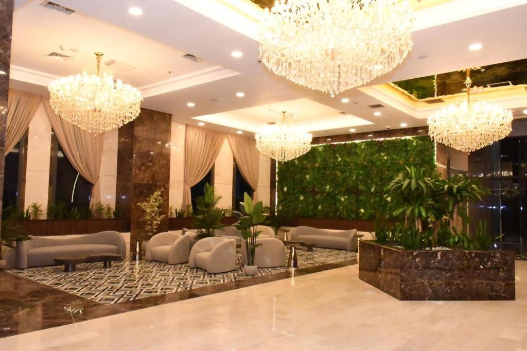 un vestíbulo con lámparas de araña y plantas en Garden Hotel en Kuwait