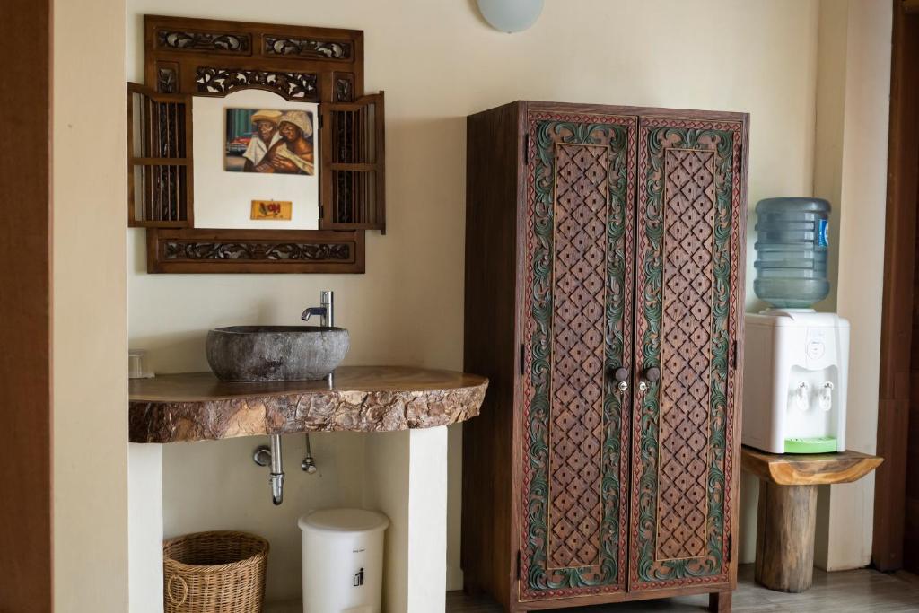 La salle de bains est pourvue d'une armoire en bois et d'un lavabo. dans l'établissement Casa Nemo Beach Resort & Spa, à Sabang