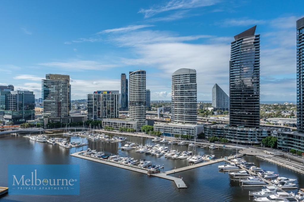 Melbourne Private Apartments - Collins Street Waterfront, Docklands في ملبورن: مدينة بها قوارب مرساة في ميناء