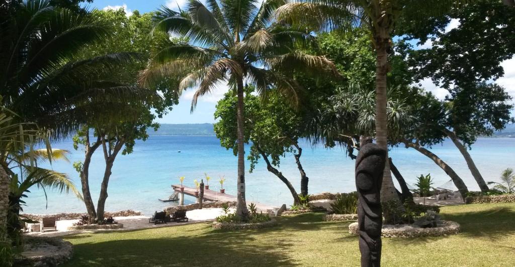 widok na plażę z palmami i ocean w obiekcie Paradise Cove Resort w mieście Port Vila