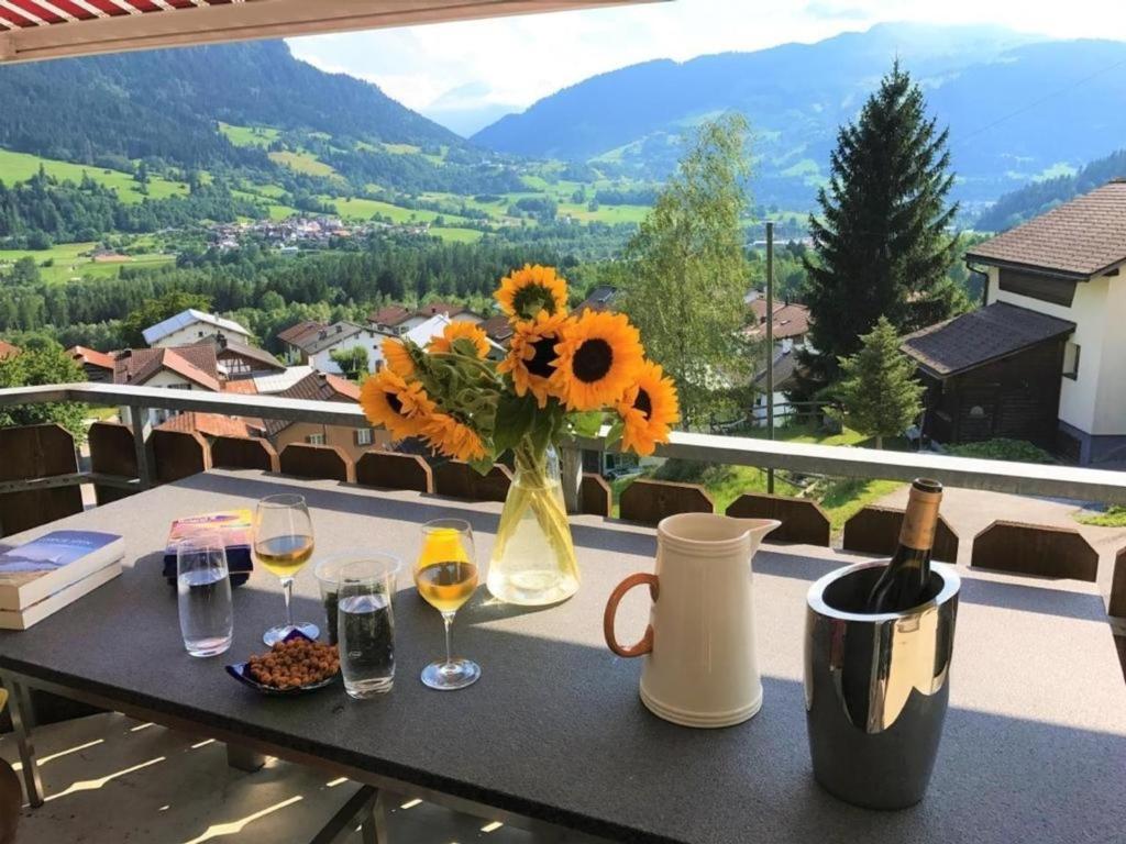 a table with a vase of flowers and wine glasses at Ferienwohnung mit Aussicht bei Golfplatz Buna Vista in Schleuis