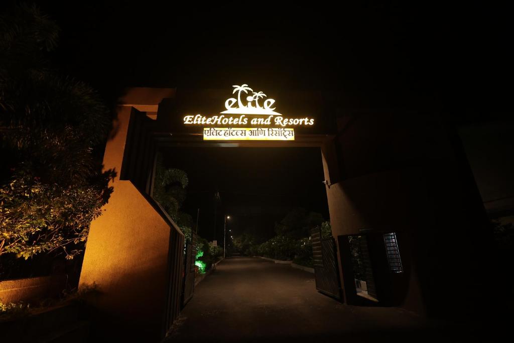 a sign for the entrance to a building at night at EliteHotels and Resorts Pvt Ltd in Alibaug