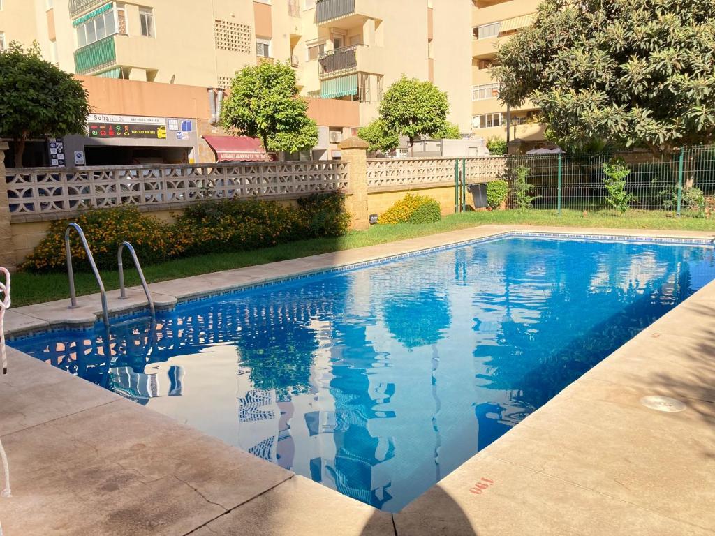 einem Pool mit blauem Wasser vor einem Gebäude in der Unterkunft Burgos 2 Terrace, pool, parking by 10ToSea in Fuengirola