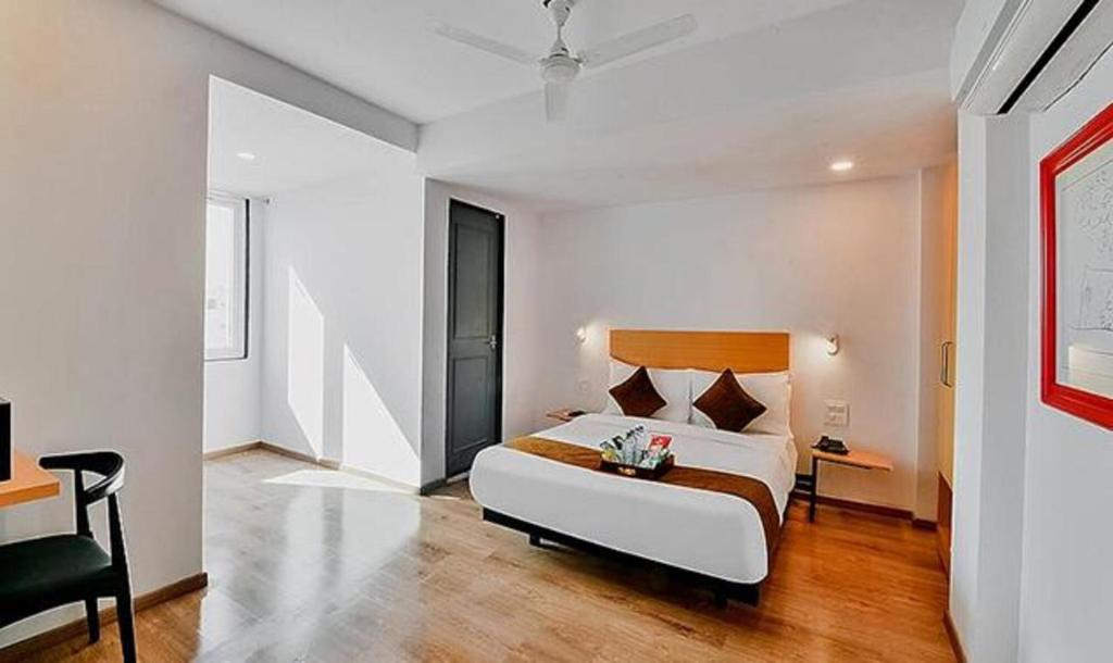 a bedroom with a bed and a desk and a chair at FabHotel Lupin Internation in Udaipur