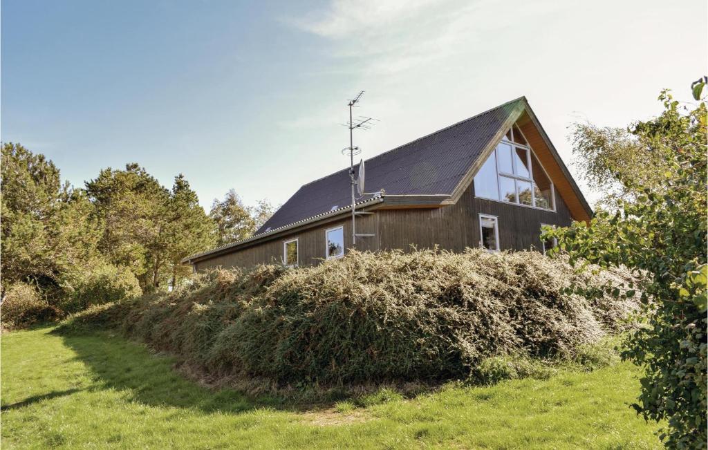エーベルトフトにあるAmazing Home In Ebeltoft With 3 Bedrooms And Wifiの緑地黒屋根の家