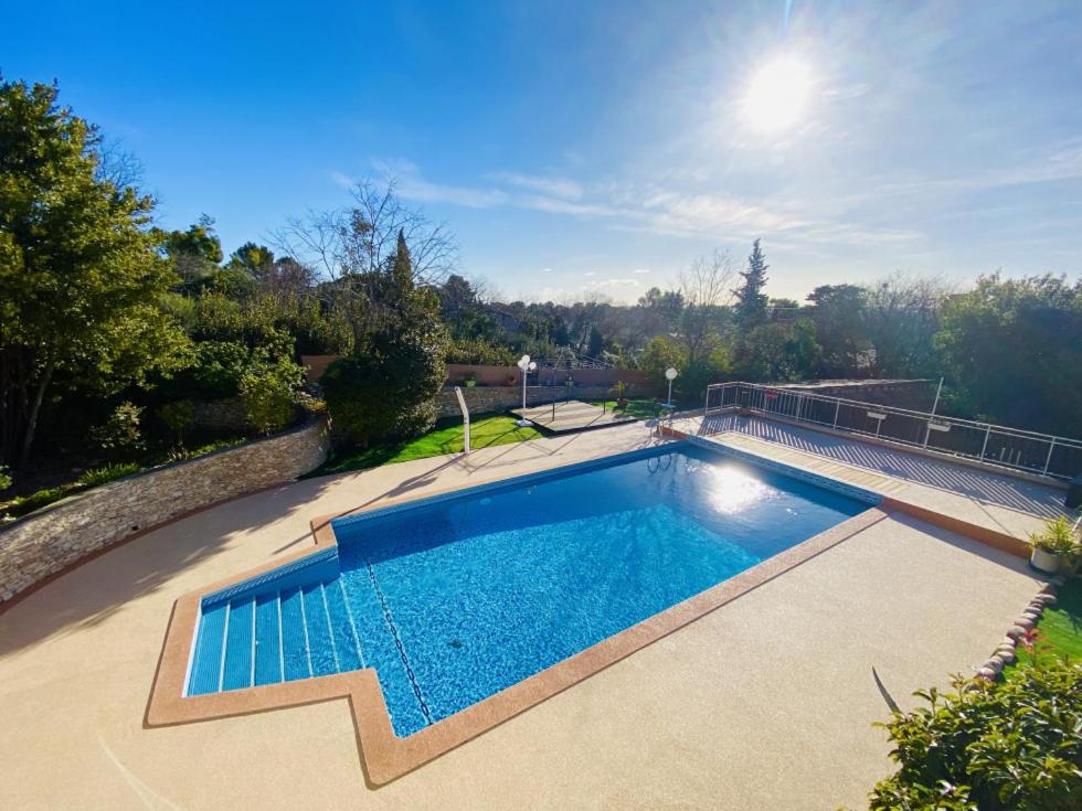 a swimming pool in the middle of a yard at Les Gites du Mas des Cigales in Nîmes