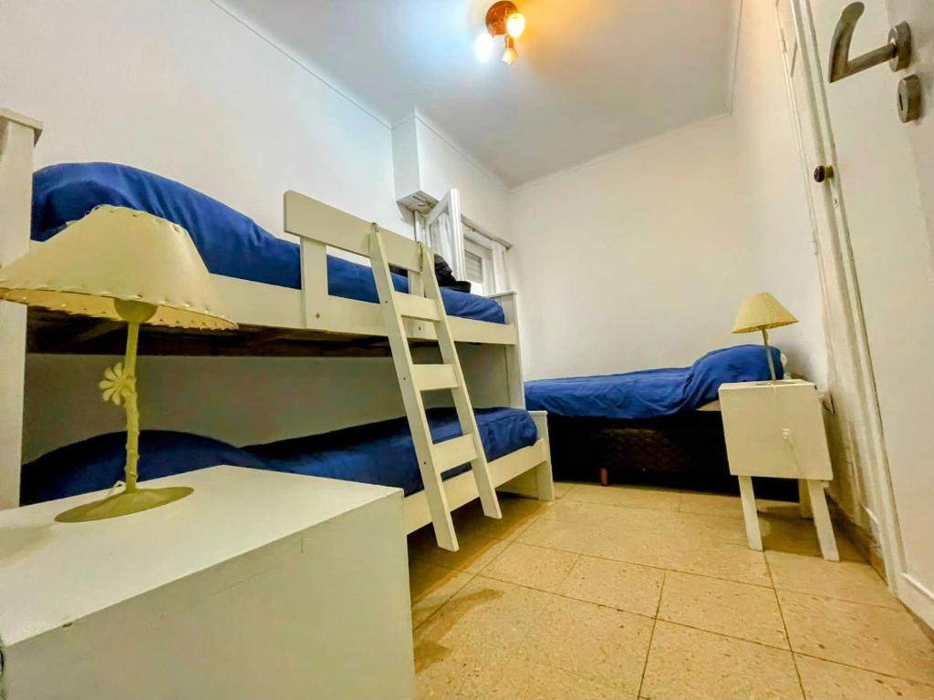 een slaapkamer met 2 stapelbedden met blauwe lakens bij Rincon Billinghurst en MDQ, departamento a 150 ms del mar, 2 dormitorios, capacidad 7 personas, solo familias, con balcon y patio, en Lamadrid 2238 Mar del Plata in Mar del Plata