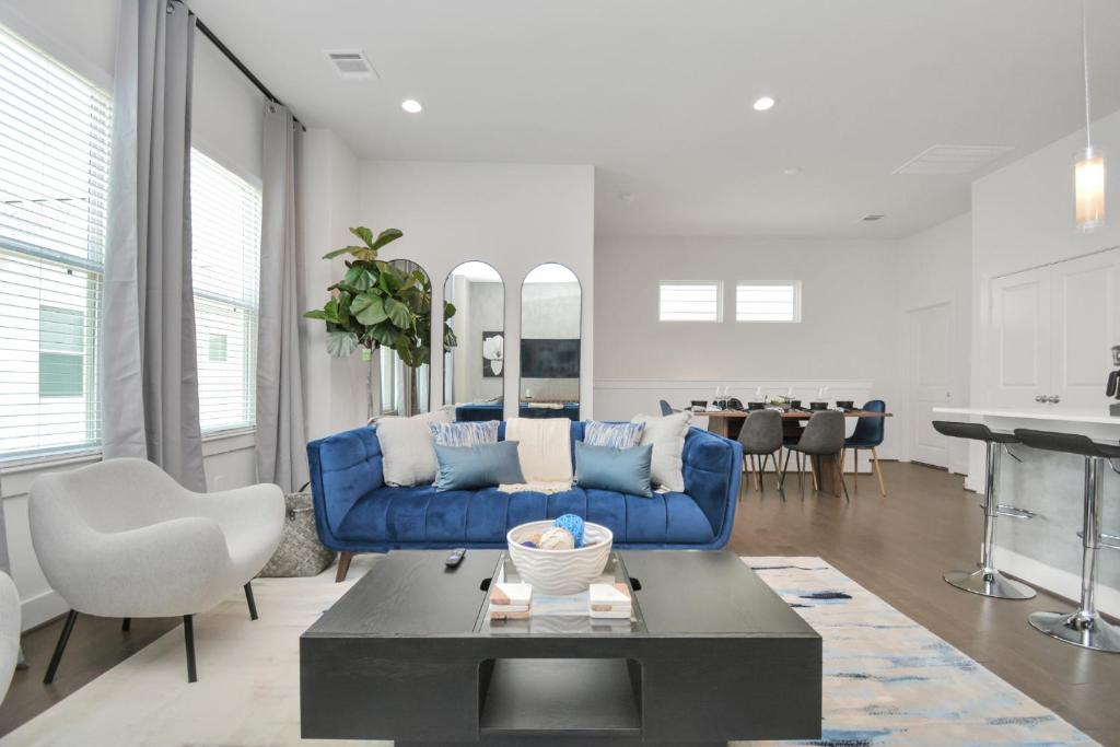 uma sala de estar com um sofá azul e uma mesa em Casa Azure - New Modern 3 BR, Med Center, NRG, UH em Houston