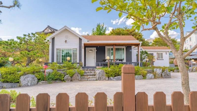 une maison avec une clôture devant elle dans l'établissement Tinkerbell detached house, à Gyeongju