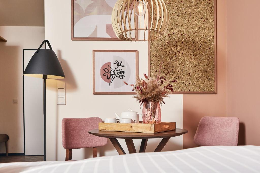 ein Schlafzimmer mit einem Tisch, Stühlen und einer Lampe in der Unterkunft HOMEBOUND APARTMENTS Bad Goisern - contactless check-in in Bad Goisern