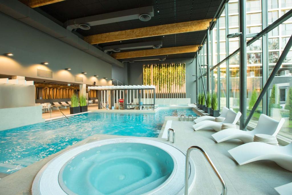 a large pool with a hot tub in a building at Hotel Jurmala Spa in Jūrmala