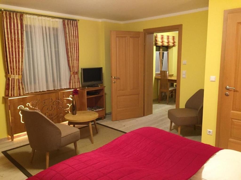 1 dormitorio con 1 cama, sillas y TV en Tolles Appartement in Marktgemeinde Übelbach mit Garten, en Übelbach