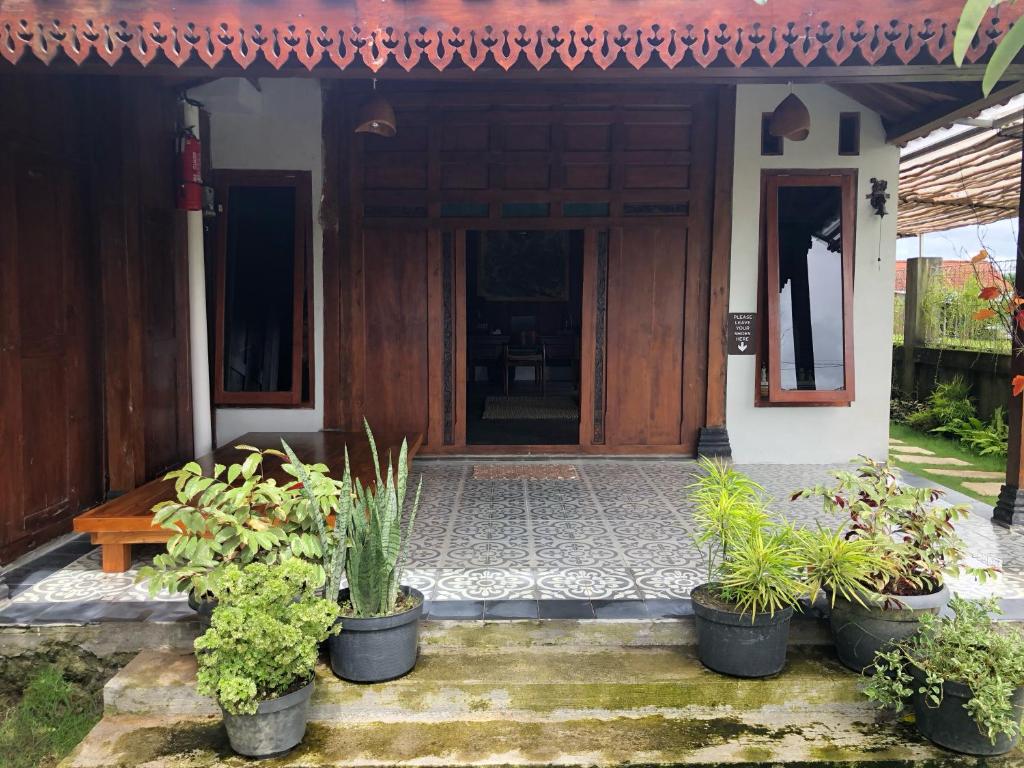 a house with pots of plants in front of it at Sawah Tamanan Villa & Resort in Yogyakarta