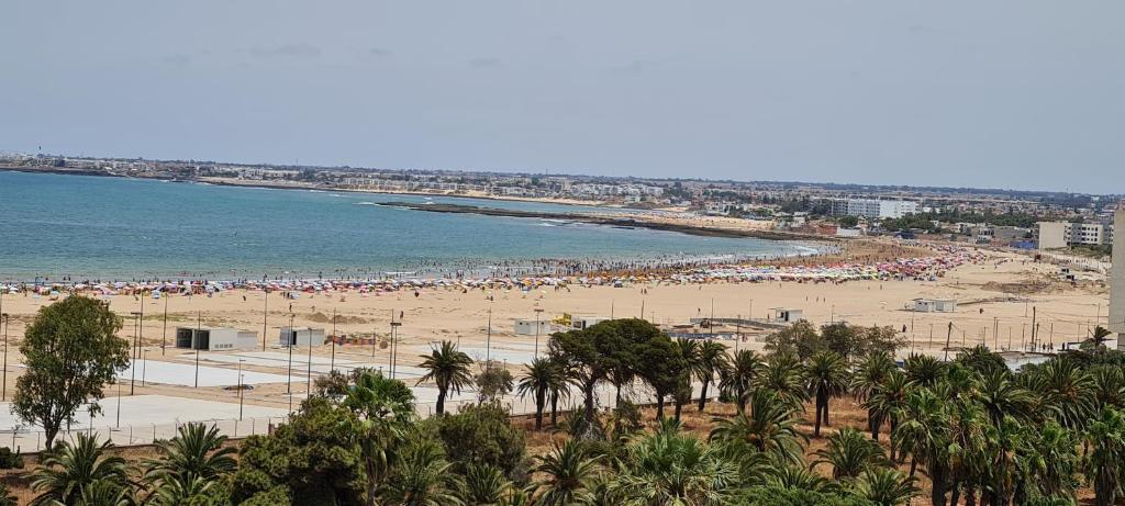 a beach with a large crowd of people at Joli appartement Mohammédia in Mohammedia
