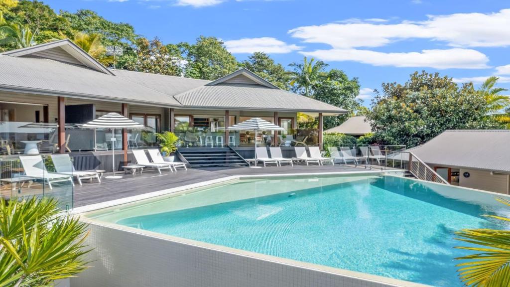 a swimming pool in front of a house at Cape Vue Studio 4 in Byron Bay