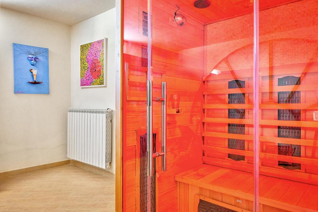 une douche avec une porte vitrée dans une salle de bain dans l'établissement Villa Il Poggino - Modern House, à Foiano della Chiana