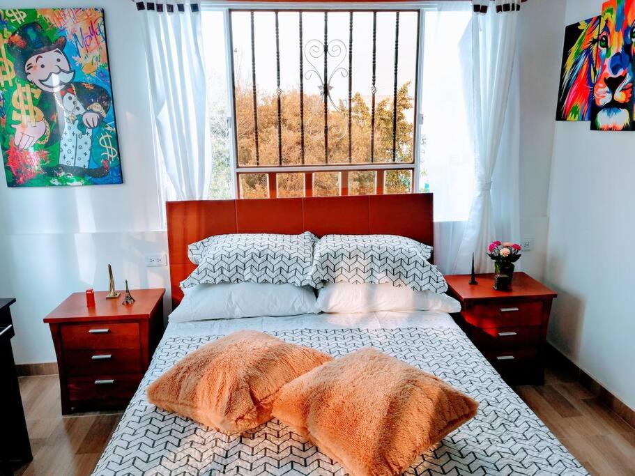 ein Schlafzimmer mit einem Bett mit zwei Kissen und einem Fenster in der Unterkunft Apartaestudio tipo LOFT INDEPENDIENTE in Bogotá