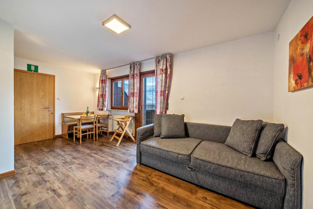 ein Wohnzimmer mit einem Sofa und einem Tisch in der Unterkunft Kammerhof Apartment Apfel in Lana