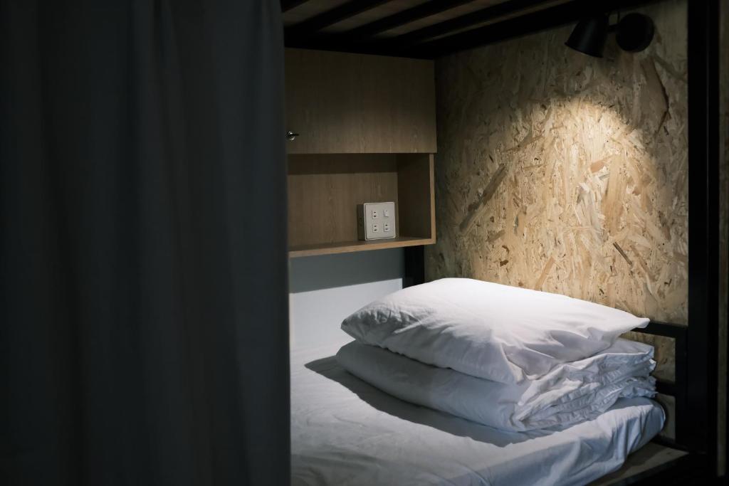 A Forest Homestay في شياوليوكيو: غرفة نوم عليها سرير ومخدات بيضاء