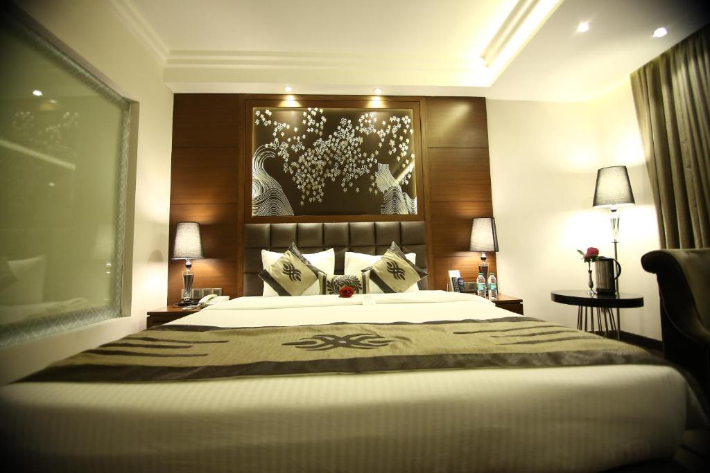 ein Schlafzimmer mit einem großen Bett und zwei Lampen in der Unterkunft Hotel JRD Exotica in Neu-Delhi