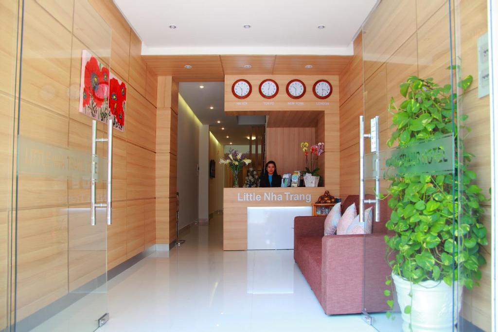 un vestíbulo con una mujer en un mostrador en una tienda en Little Nha Trang Hotel, en Nha Trang