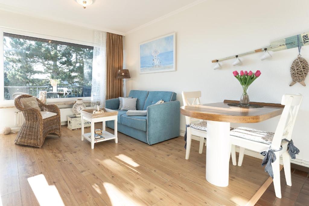 uma sala de estar com um sofá azul e uma mesa em Haus Baltic Wohnung 20 em Scharbeutz