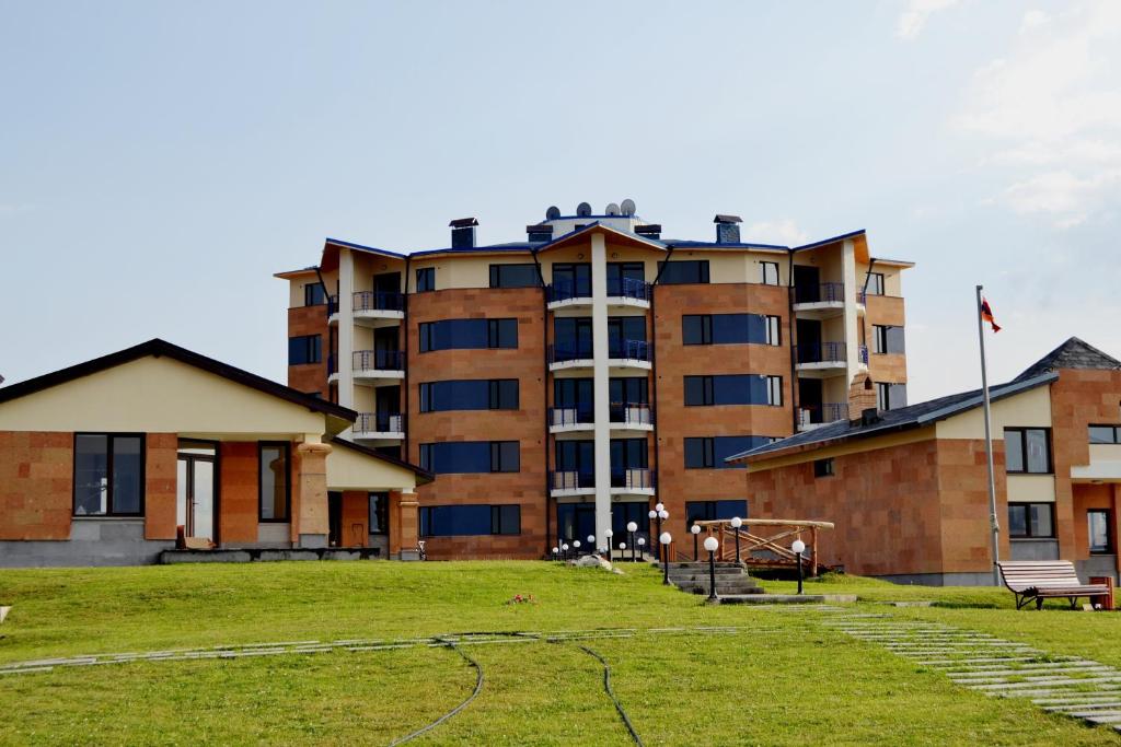 un gran edificio de apartamentos con un parque enfrente en Tsovasar Family Rest Complex en Sevan