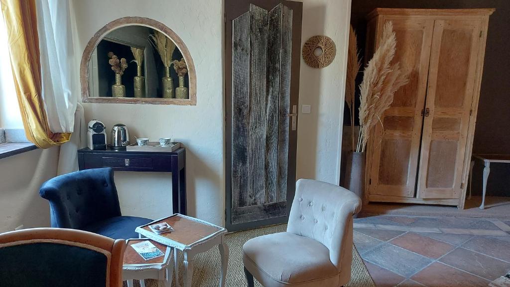 ein Wohnzimmer mit 2 Stühlen und einem Tisch in der Unterkunft La demeure des poètes chambres d'hôtes in Les Cabannes