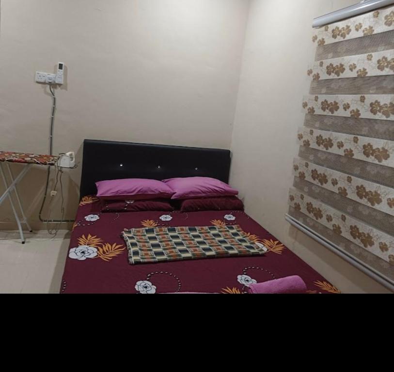 uma cama com um tabuleiro de xadrez num quarto em HOMESTAY BY ZIKRY em Kota