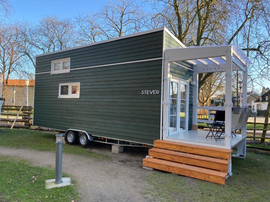 a green tiny house sitting on a trailer at Tiny House Stever im PIER9 Tiny House Hotel in Hamm