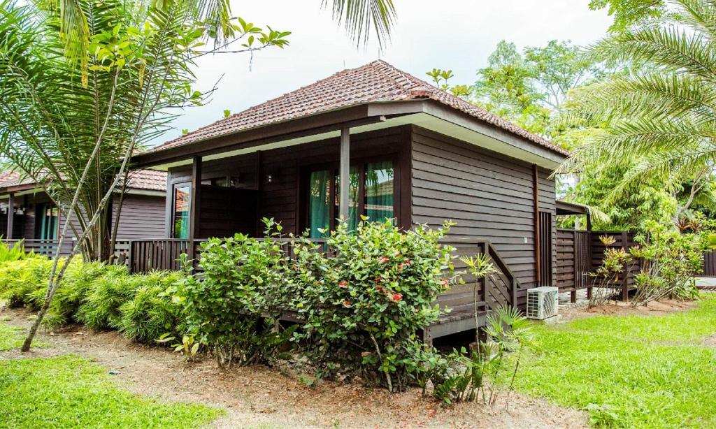a small house in a yard with trees and plants at Kranji Sanctuary Resort in Singapore